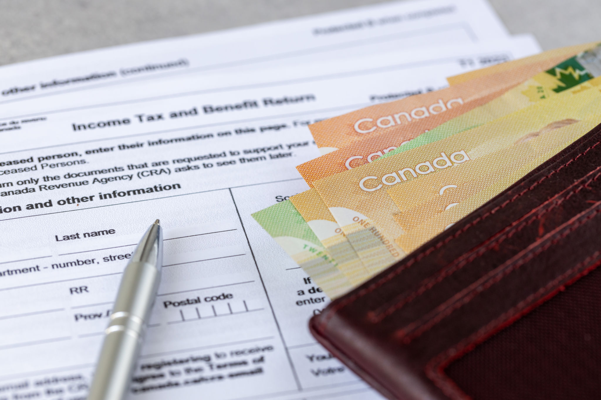 Canada. Income tax and benefit return. tax forms and Canadian dollars and pen, financial concept. close up Canada. Income tax and benefit return. tax forms and Canadian dollars and pen, financial concept. close up