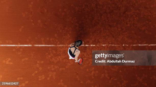 tennis player walking on clay court with racket: aerial view - clay court stock pictures, royalty-free photos & images