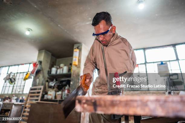 amputee carpenter sawing a wood on a woodshop - workbench stock pictures, royalty-free photos & images