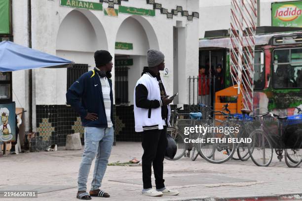 Migrants from sub-Saharan Africa stand on a sidewalk in Ariana near Tunis on February 1, 2025. Tunisia, as well as neighbouring Libya, is a key...