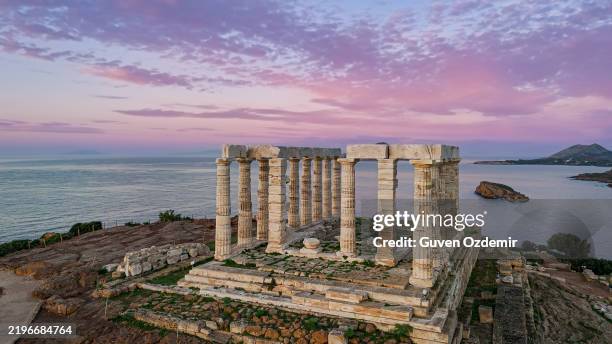 veduta aerea del tempio di poseidone a capo sunio durante il tramonto, che mette in mostra l'iconica architettura greca antica circondata dal mar egeo, un punto di riferimento storico e culturale, perfetto per il patrimonio e i concetti di viaggio - mitologia foto e immagini stock