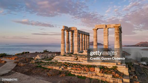 vista aérea del templo de poseidón en el cabo sounion durante la puesta de sol, mostrando la icónica arquitectura griega antigua rodeada por el mar egeo, un hito histórico y cultural, perfecto para el patrimonio y los conceptos de viaje - grecia europa del sur fotografías e imágenes de stock
