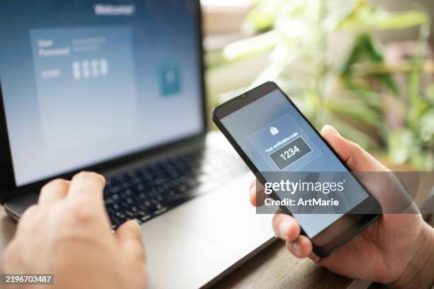 mann mit smartphone und laptop versucht, sich mit zwei-faktor-authentifizierung anzumelden. datensicherheitskonzept. - digitale authentifizierung stock-fotos und bilder