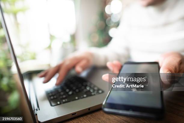 hombre con teléfono inteligente y computadora portátil tratando de iniciar sesión con autenticación de dos factores. concepto de seguridad de datos. - corrupción corporativa fotografías e imágenes de stock