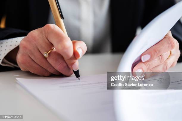businesswoman signing a contract at office desk - signature stock pictures, royalty-free photos & images