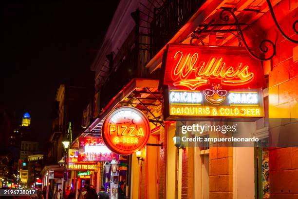 new orleans, louisiana in mardi gras carnival celebrations. neon signs illuminating new orleans' vibrant nightlife on bourbon street during mardi gras - bourbon street new orleans stock pictures, royalty-free photos & images