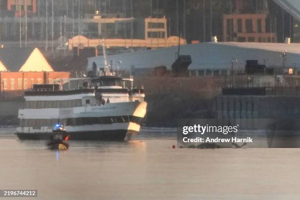 Emergency response units search the crash site of the American Airlines plane on the Potomac River after the plane crashed on approach to Reagan...