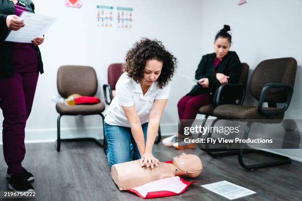 dentist office employees practice cpr on a dummy - cpr stock pictures, royalty-free photos & images