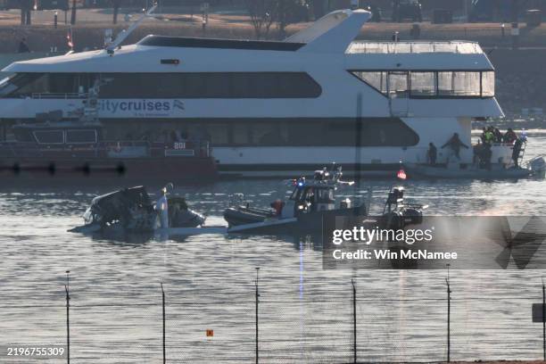 Emergency response units search the crash site of the American Airlines plane on the Potomac River after the plane crashed on approach to Reagan...