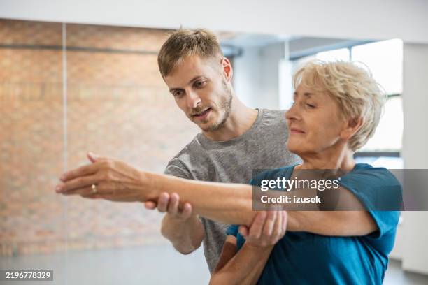 ältere frau training mit personal coach auf der rehab - physiotherapie stock-fotos und bilder