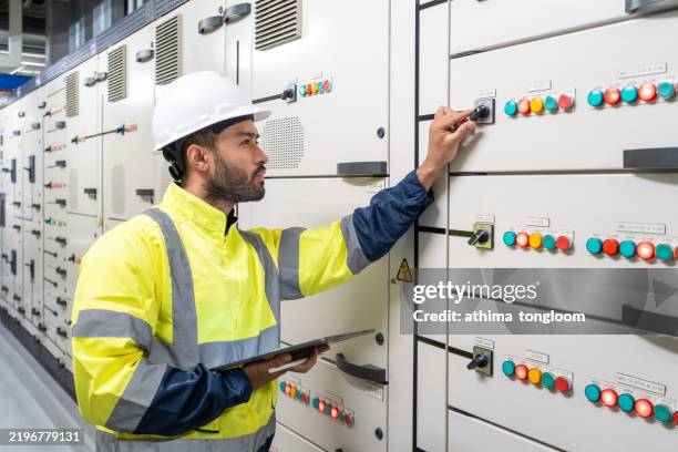 marine engineer officer starts or stops main engine of ship in engine control room ecr. seamen's work. - marine photos et images de collection