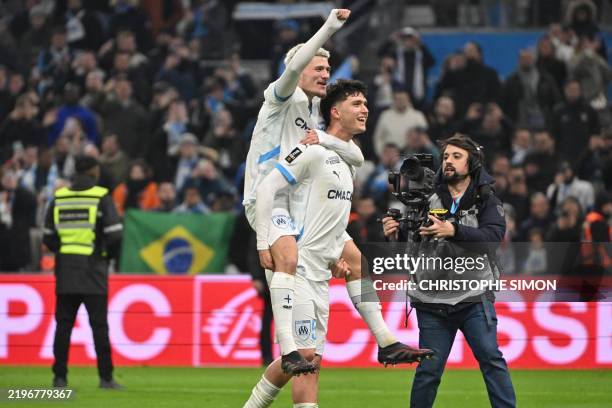 Marseille's French defender Quentin Merlin celebrates after winning with Marseille's Argentinian defender Leonardo Balerdi the French L1 football...