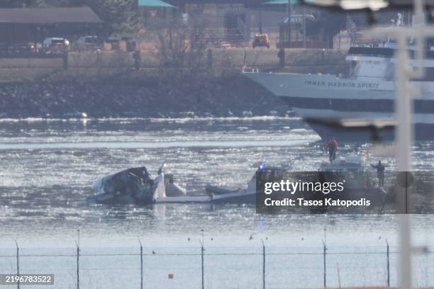 Emergency response units search the crash site of the American Airlines plane on the Potomac River after the plane crashed on approach to Reagan...