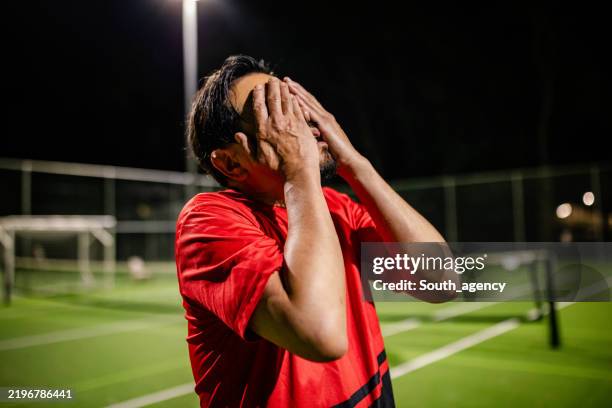 men engage in nighttime soccer match on a field in sydney, showcasing teamwork and active lifestyles - failure stock pictures, royalty-free photos & images