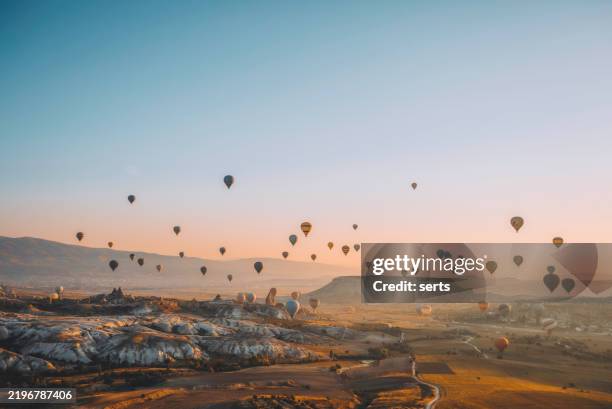 globos aerostáticos flotando sobre capadocia, turquía al amanecer - patrimonio de la humanidad por la unesco fotografías e imágenes de stock