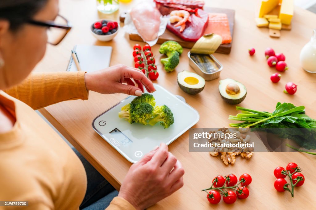 Woman using weight scale to get the proper serving size of food. Healthy eating concept
