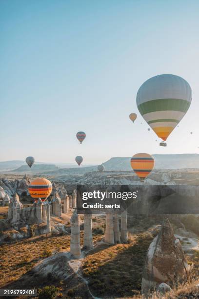 montgolfières flottant au-dessus des cheminées de fées en cappadoce, turquie - cheminée de fée photos et images de collection