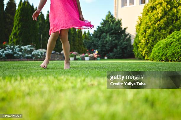 niña corriendo sobre césped verde. - green de golf fotografías e imágenes de stock