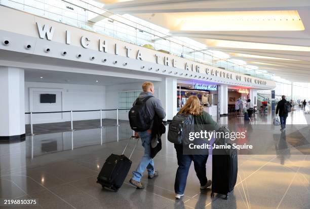 Travelers walk through Dwight D. Eisenhower National Airport on January 30, 2025 in Wichita, Kansas. An American Airlines flight from Wichita, Kansas...