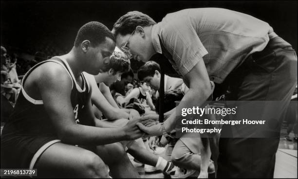 Manor Baptist High School basketball player Cedric Goodman listens to assistant coach Shawn Ragan during a timeout in a game, Oakland, California,...
