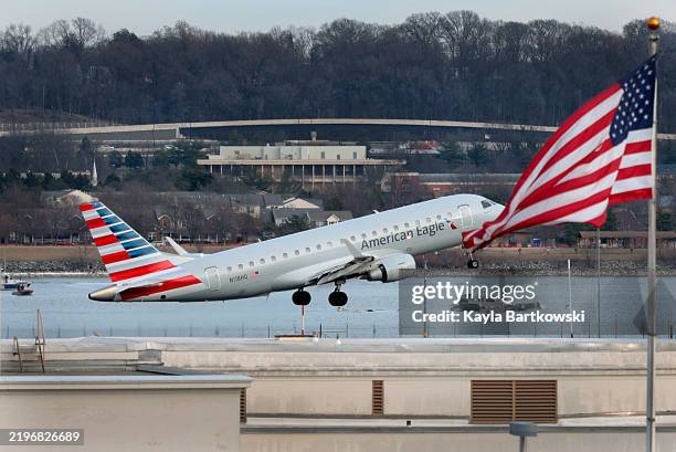 An American Airlines aircraft takes off from Ronald Reagan Washington National Airport as emergency workers continue to search the wreckage of the...