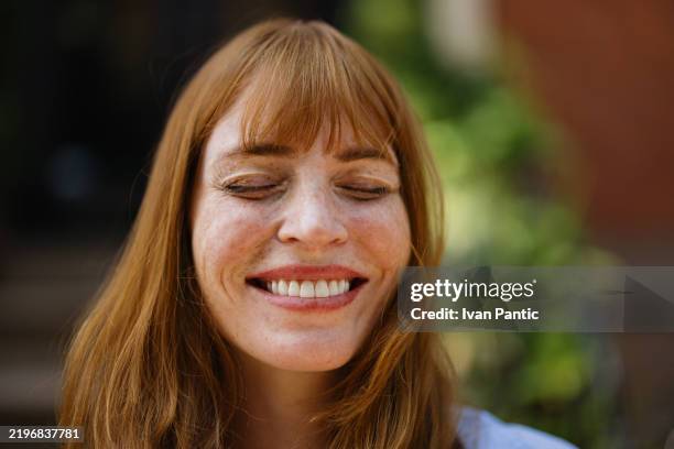 donna che sorride brillantemente in un ambiente esterno pieno di sole - lentiggine foto e immagini stock