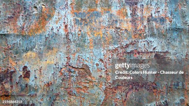 close-up of a rusty and patinated metal plate painted blue. very rough texture. sunlight. colors. paris, france. - rust colored stock pictures, royalty-free photos & images