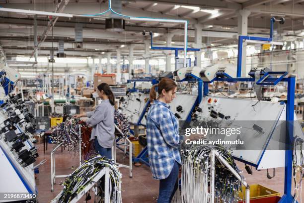 industrial worker woman soldering cables of manufacturing equipment in a factory - equipamento elétrico equipamento de recreio imagens e fotografias de stock