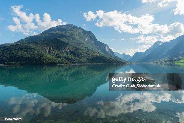 barca sull'idilliaco lago turchese in norvegia - lago reflection foto e immagini stock