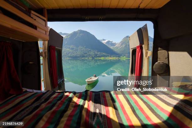 camper van interior with view of turquoise lake in norway - caravan stockfoto's en -beelden