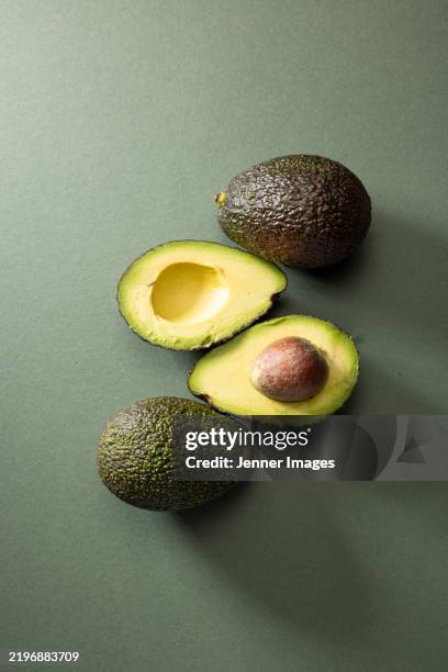 fresh avocado on a dark green background. super food vegetables - avocado stock-fotos und bilder
