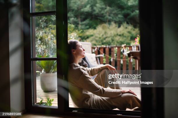 woman resting in doorway of balcony doors, resting. single woman enjoying free weekend. concept of selfcare. - zen bildbanksfoton och bilder