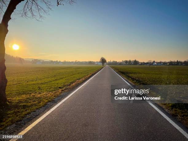 empty field road with sunset - freie straße stock-fotos und bilder