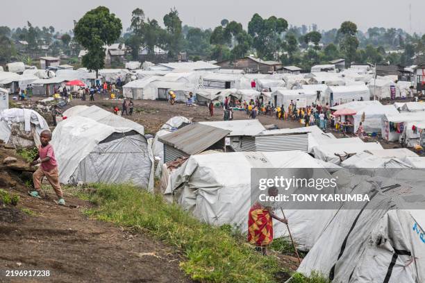 Internally displace persons go about their daytime activities at Lushagala camp for Internally Displaced Persons in the city of Goma, the capital and...