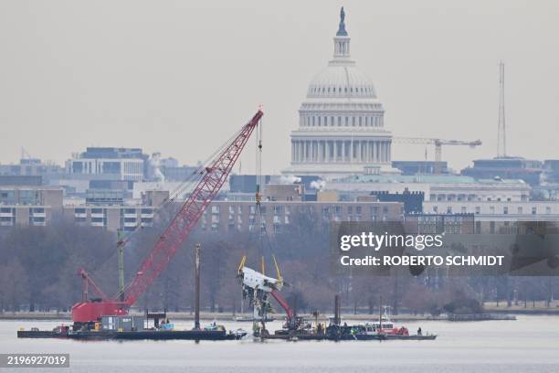 Crane removes airplane wreckage from the Potomac River, where American Airlines flight 5342 collided with a US Army military helicopter, near Ronald...