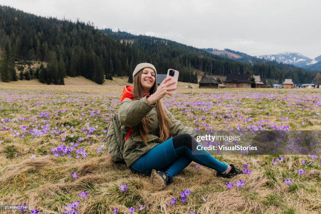 Glückliche Frau, Die Sich Auf Einer Wiese Entspannt Fotografierende Blühende Safron Krokusse Im Tatra-Gebirge