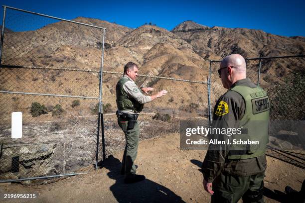 Altadena, CA Los Angeles County Sheriff's detectives Jeff Lohmann, left, and David Gaisford view the area of Eaton Canyon where the Eaton fire was...