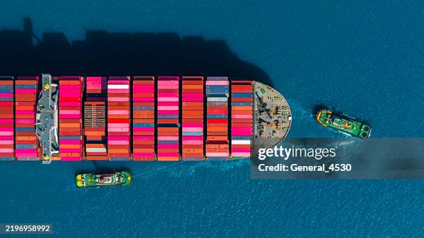 aerial top view tugboat pushing container ship to quayside for unload container at blue sea. - shipping container top view - fotografias e filmes do acervo