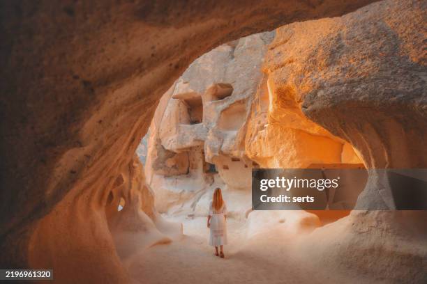 femme explorant d’anciennes habitations troglodytes en cappadoce, turquie - cheminée de fée photos et images de collection