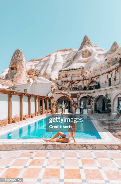 woman relaxing by a luxury cave hotel pool in cappadocia, turkiye - capadócia imagens e fotografias de stock