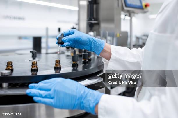 travailleurs de l’industrie pharmaceutique sur la chaîne de production pour le remplissage et l’emballage de bouteilles. - cosmétique photos et images de collection