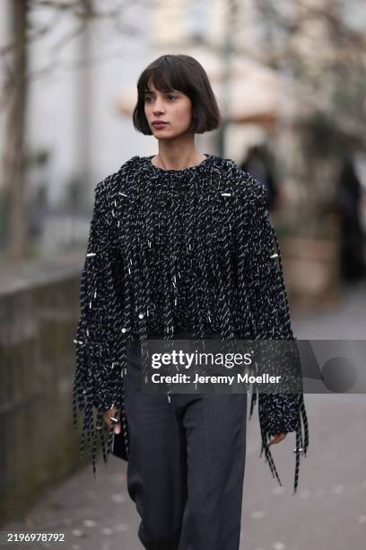Iman Perez seen wearing a glittery black shimmery shirt, dark grey wide pants outside Sacai Show during the Menswear Fall Winter 2025/2026 as part of...