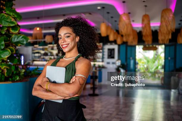 confident woman standing in modern cafe with tablet - small restaurant interior stock pictures, royalty-free photos & images