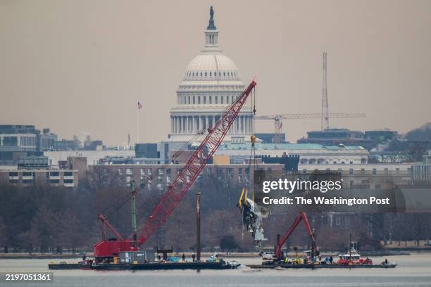 Alexandria, VA A crane is seen from Virginia as it removes airplane wreckage from the Potomac River, where American Airlines flight 5342 collided...