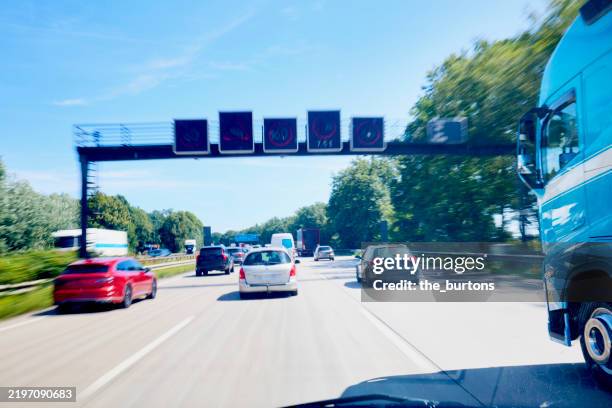 car ride on a crowded autobahn, looking forward through the windshield - autobahn foto e immagini stock