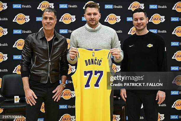 Slovenian basketball player Luka Doncic holds up a jersey as he stands alongside Los Angeles Lakers head coach JJ Redick and Los Angeles Lakers...