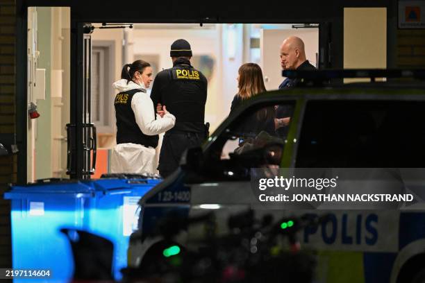 Forensic police officers work at the scene of the Risbergska School in Orebro, Sweden, on February 4 following reports of a serious violent crime....