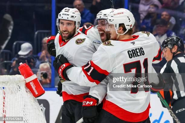 Michael Amadio of the Ottawa Senators, left, celebrates his goal against the Tampa Bay Lightning with teammates, including Ridly Greig during the...