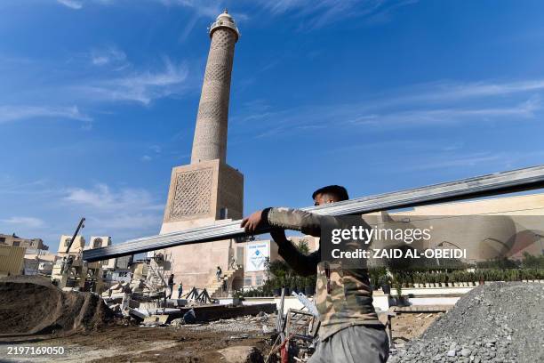 Builders work on the ongoing reconstruction of the historic Great Mosque of al-Nuri, whose "Al-Hadba" leaning minaret which dates back to the 12th...