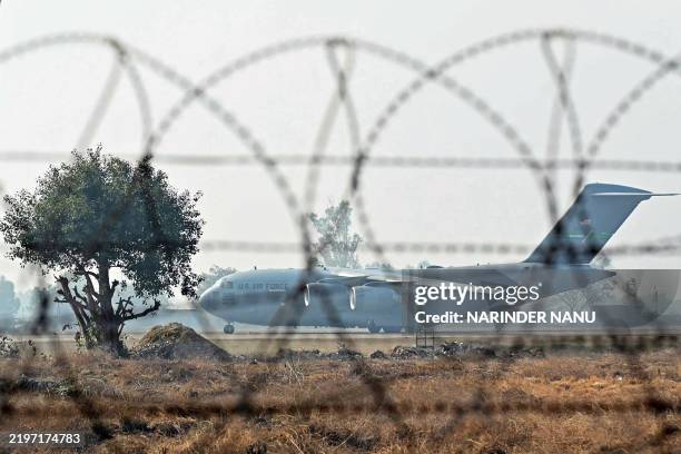 Air Force aircraft carrying Indian migrants deported from the United States, lands at the Guru Ram Das Jee International Airport in Amritsar on...